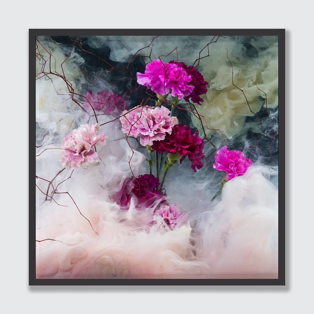 A framed square art print featuring pink and magenta flowers emerging from swirling white, gray, and pale green smoke, set against a light gray background.