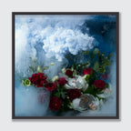 A framed square art print featuring a still life of red and white flowers with green leaves set against a smoky blue and white background, displayed on a light gray wall.