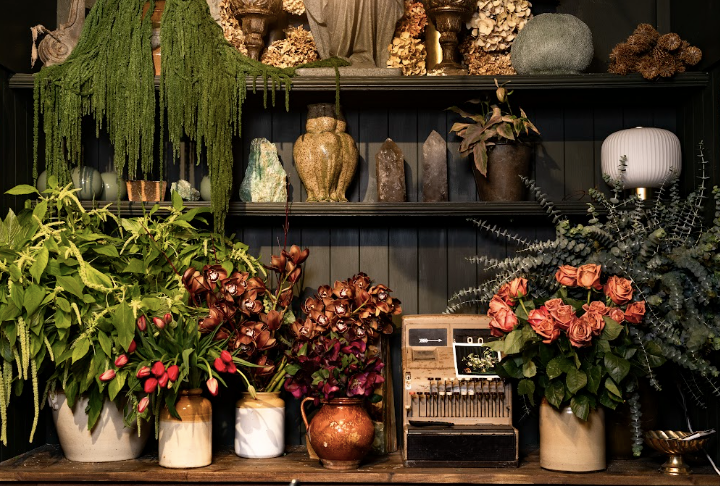 Florist shelving with handmade vases ad bouquets in a dark space