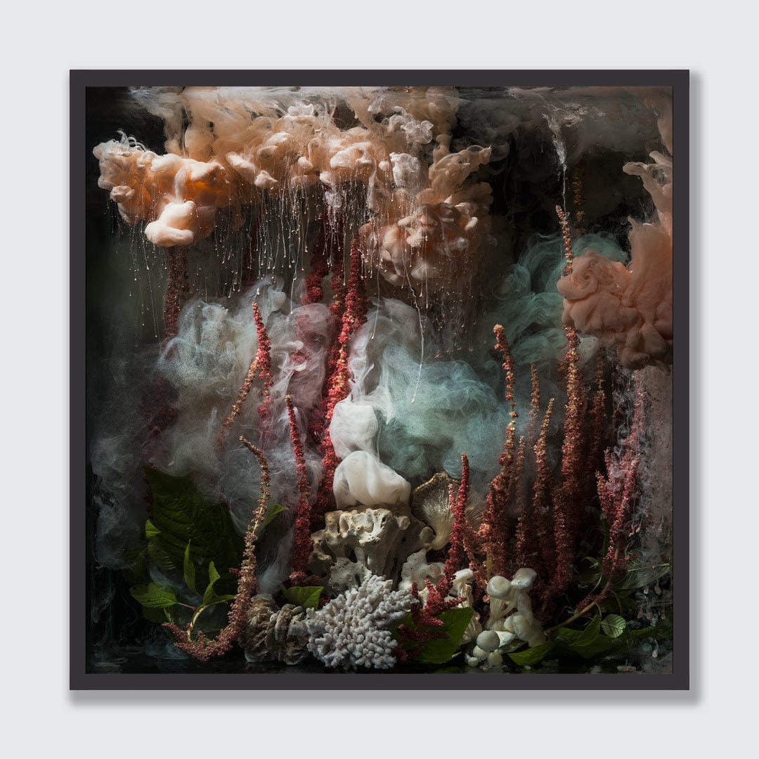 A framed square art print featuring an abstract, painterly scene with flowing beige and white forms, red vertical streaks, pale blue haze, dark shadows, and green leaves at the bottom, shown against a light gray background.