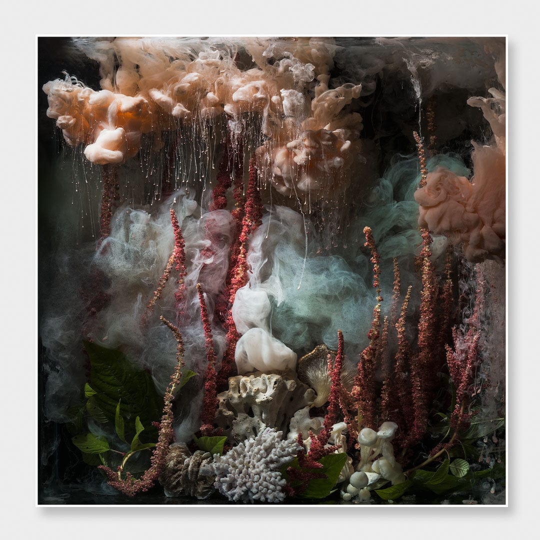 An abstract, painterly composition with smoky peach, gray, and teal forms, red vertical spires, white sculptural elements, and dark shadowy areas, presented as wall art with a thin white border.