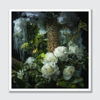 A framed floral still life artwork featuring white flowers, green leaves, and textured botanical elements against a dark background, presented with a white border on a light gray backdrop.